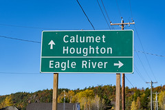 Road sign giving directions to cities in the Upper Peninsula of Michigan - Eagle River, Calumet, and Houghton