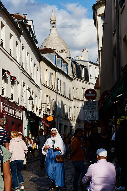 Crowd full of both tourists and french people, walking in Montmartre in the sunlight, Paris, France
