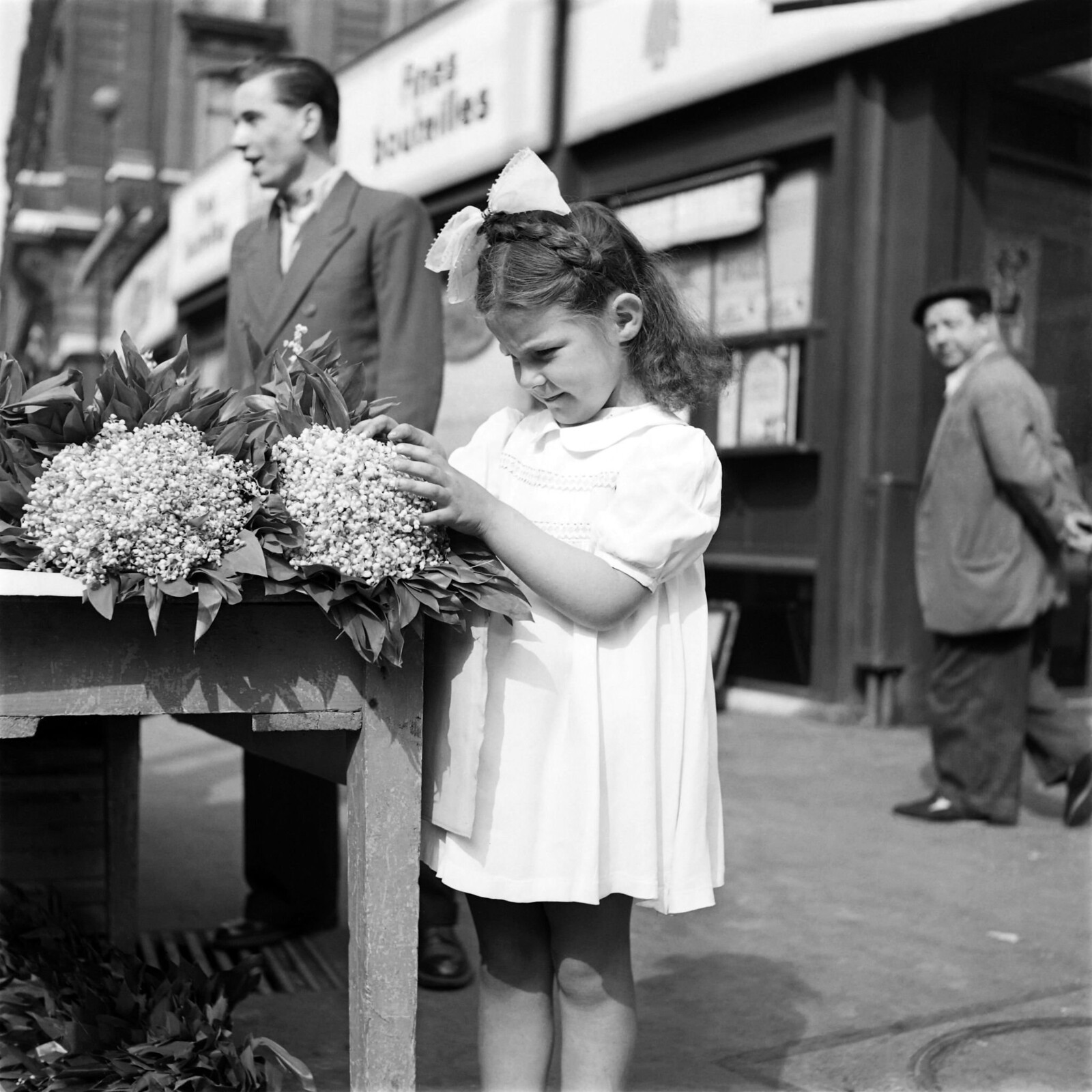 1952. Маленькая девочка раскладывает цветы ландышей 1 мая