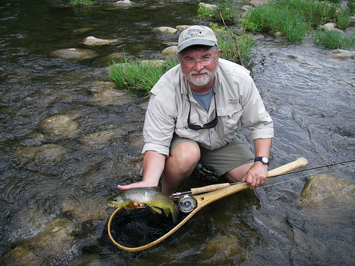 Photo of man in a creek with a fishing net