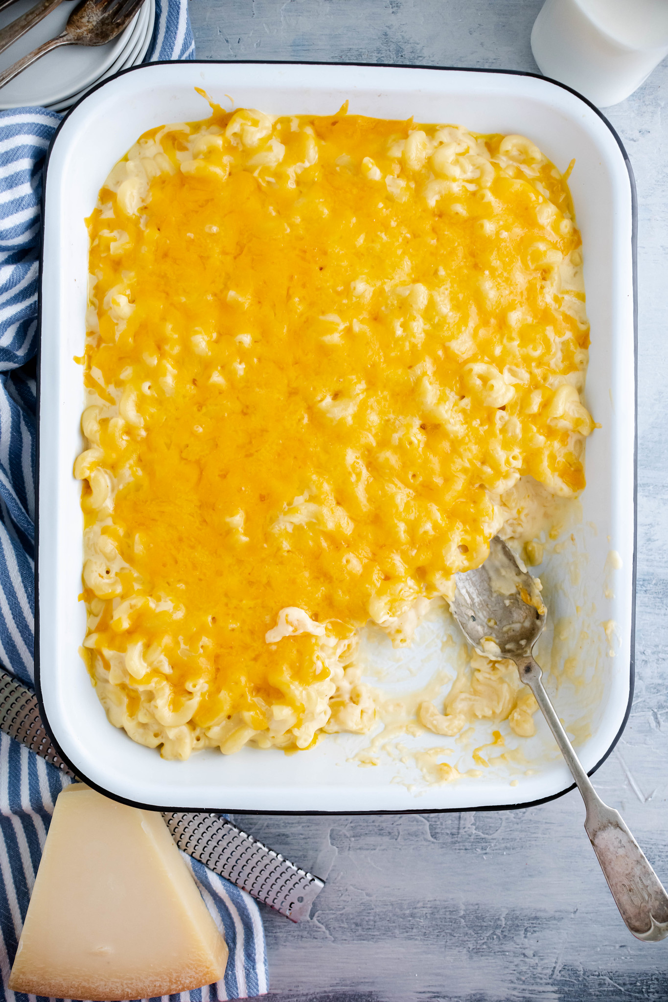 13x9 pan of macaroni and cheese with a corner of macaroni scooped out.
