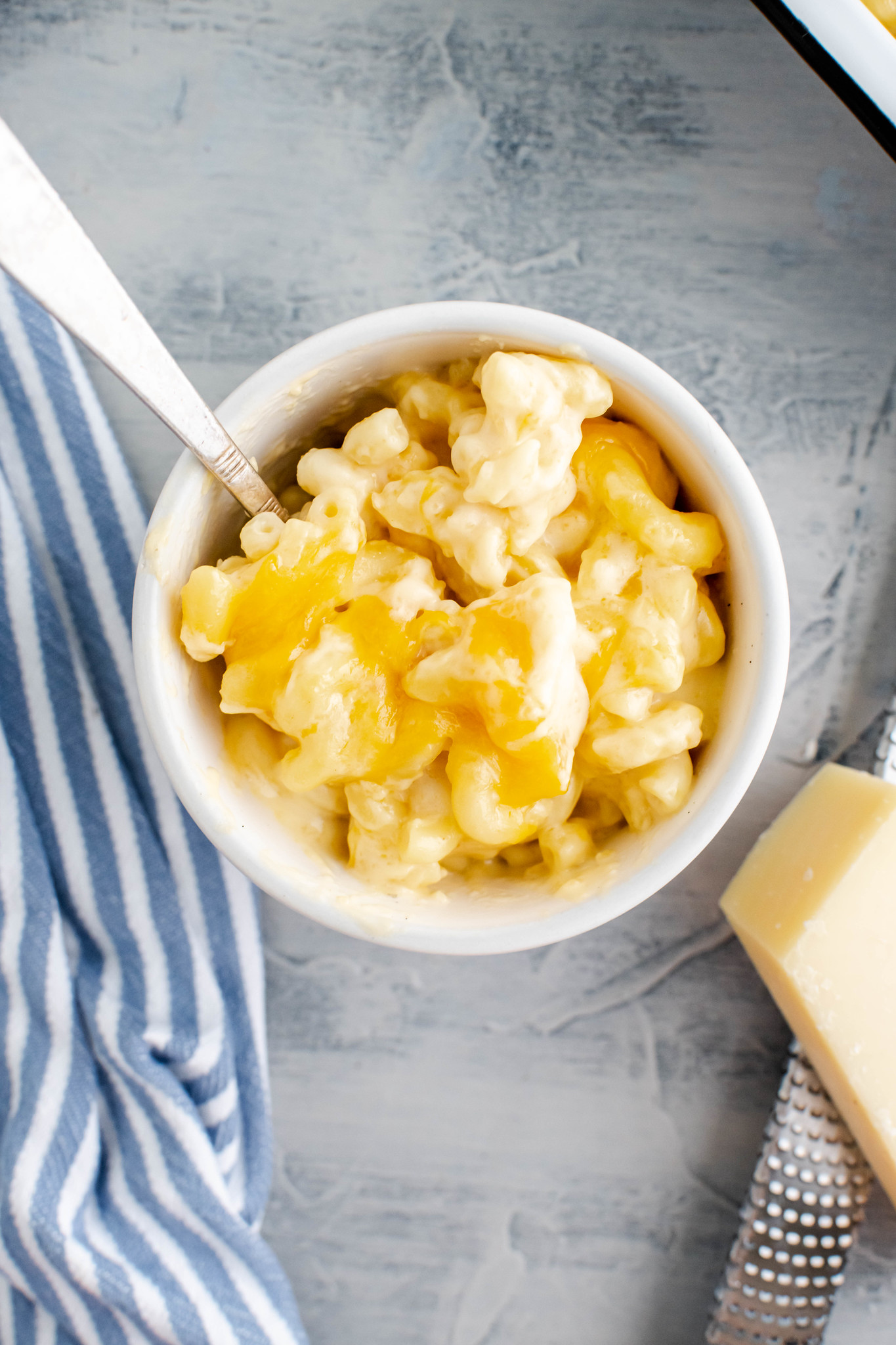 Pale grey bowl of macaroni and cheese.