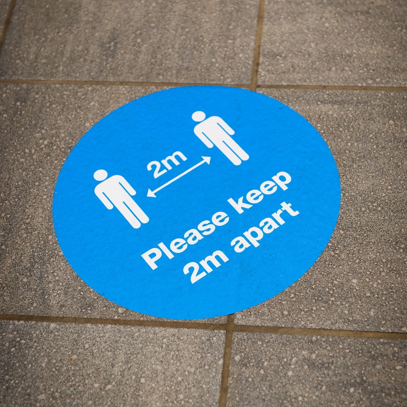 A COVID restriction floor sign on campus
