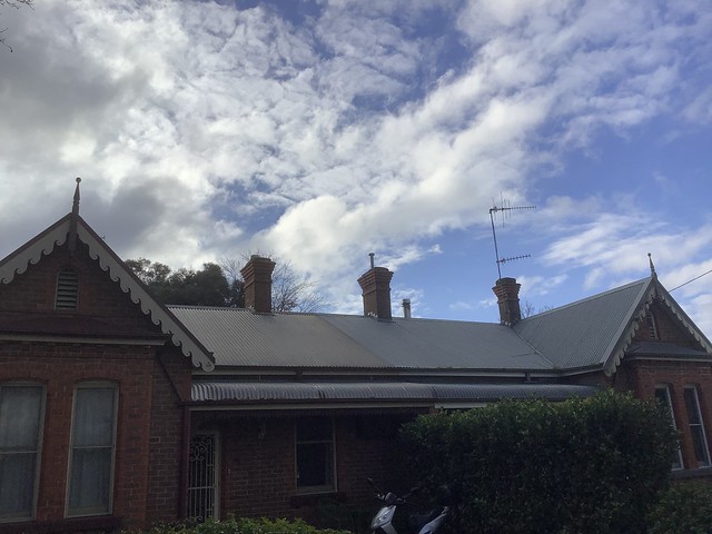 Corrugated roofing iron, finials and chimneys, with clouds