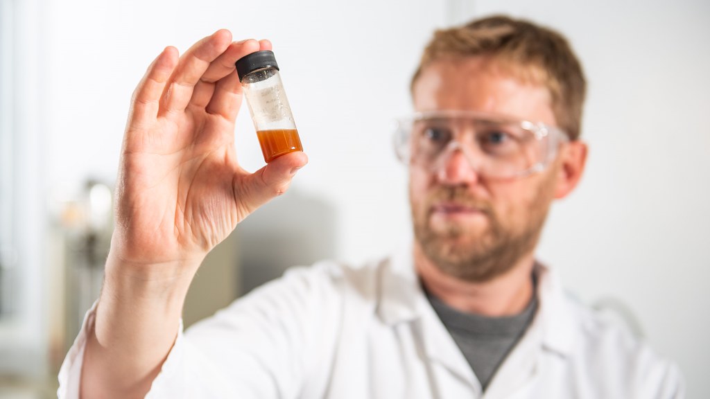 Professor Chris Chuck holding a vial of oil that could be used as an alternative to palm oil