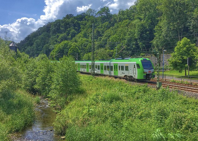 A German train passes by in the beautiful green landscape of Langenberg in Velbert on a very sunny spring day