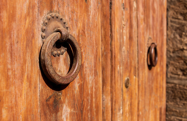 Two Doorknobs On An Old Wooden Door