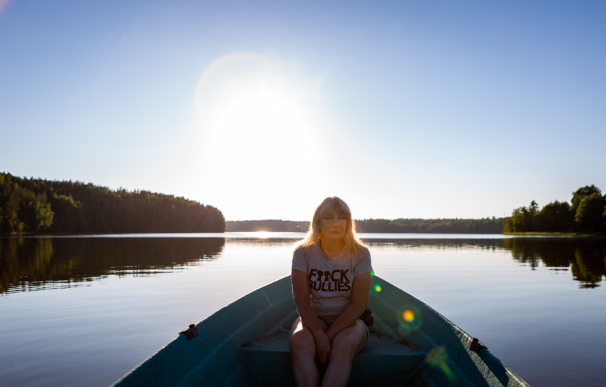 nainen soutuveneessä ilta-auringossa