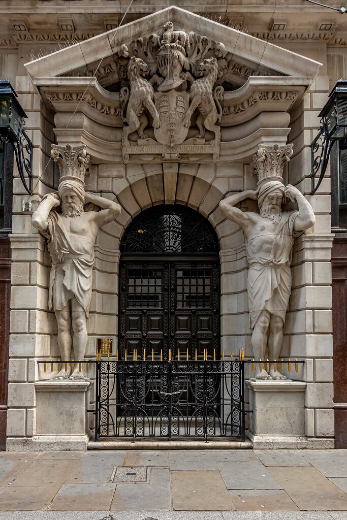 Dating from the 1770's, Drapers Hall, Throgmorton Avenue, is home to the Worshipful Company of Drapers, one of London's twelve great historic livery companies.
The two pillars are statues of male turbaned Djinns. Sculpted by H. A. Pegram.