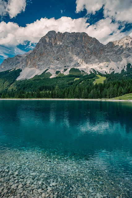 clear water, green fir trees and wild mountains