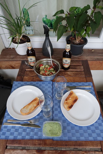 Aufgebackenes Baguette mit Bärlauchbutter zu Tomaten-Gurken-Salat (Tischbild)