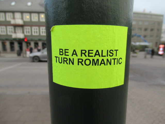Be a realist, turn romantic: sticker on post at Lækjartorg, Reykjavík, Iceland