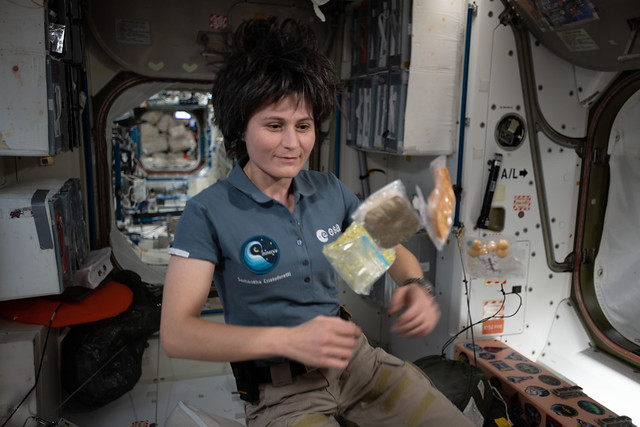 Astronaut Samantha Cristoforetti poses with food packets