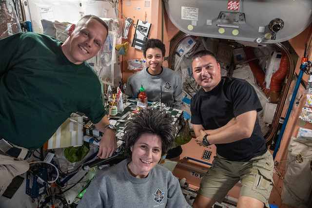 Expedition 67 flight engineers pose for a portrait during dinner time