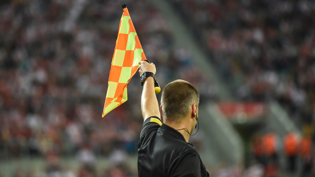 Football referee holding up flag