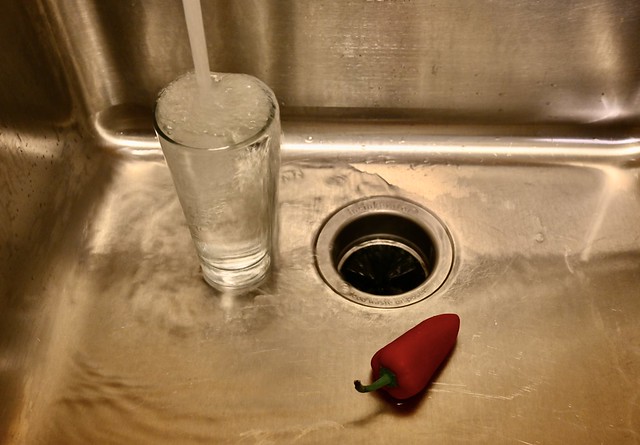 Water Glass in Sink with Red Pepper