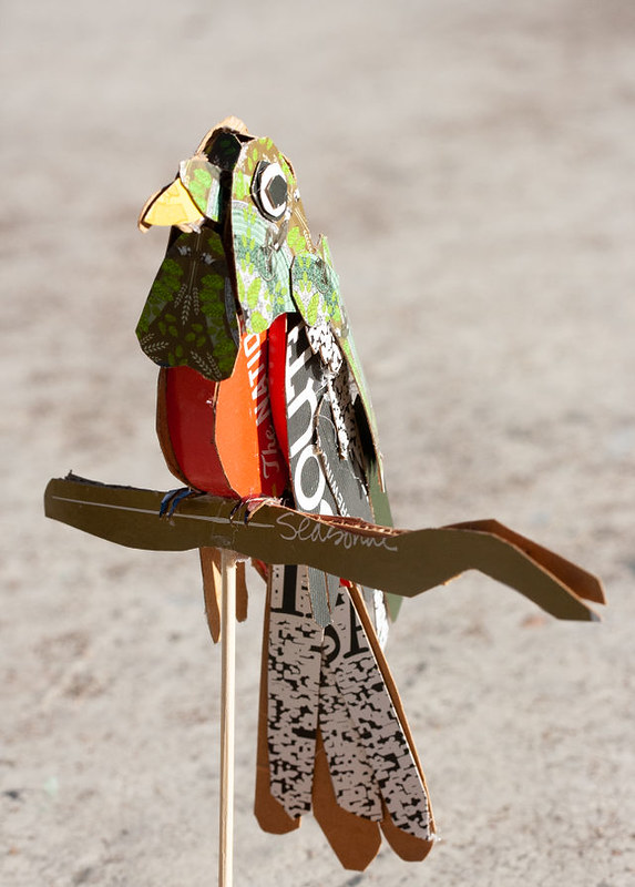 Front view of the same sculpture, showing the hanging 'feathers' over the red breast, the words 'The national' can be seen printed on the red, part of Lone Star's slogan, and the inside tail is black splattered like television fuzz