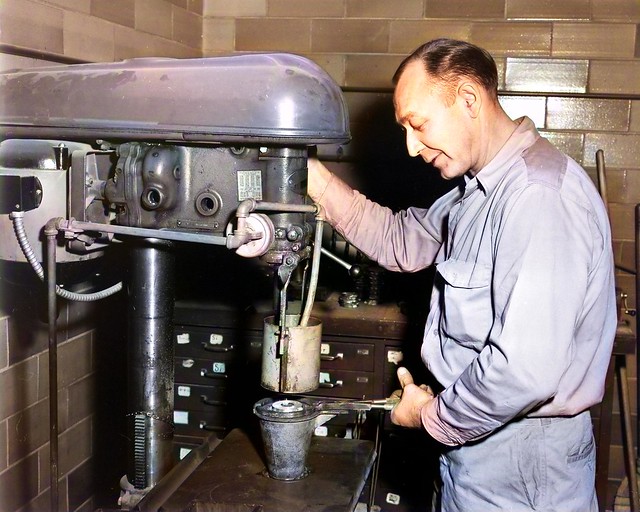 Man operating a drill press at a factory in 1950, colorized by Asar Studios