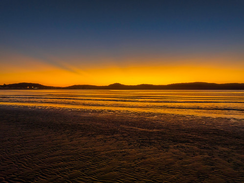 Aerial sunrise seascape with orange glow on a cold Winter's morning by Merrillie, Sunrise seascape with calm sea and clear skies at Umina Point, Umina Beach on the Central Coast, NSW
