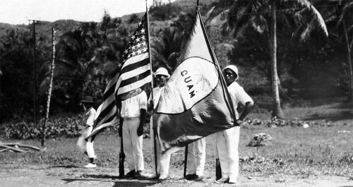 Fanohge CHamoru Exhibition Section 5: Oral Histories and Intergenerational Conversations. Guam Insular Force Guard parade, displaying of Guam Flag, ca. 1917. Guam Public Library System Collection.