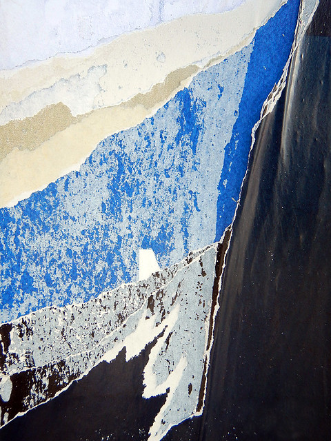 abstract of torn posters forming an image of a blue mountain