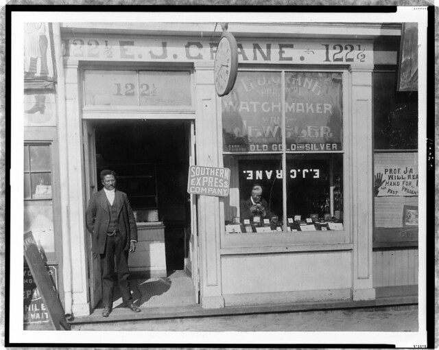 [E.J. Crane, watchmaker and jewelry store with man working in window and man standing in doorway, Richmond, Virginia] (LOC)