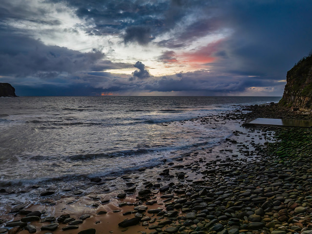 Moody sunrise seascape with rain clouds