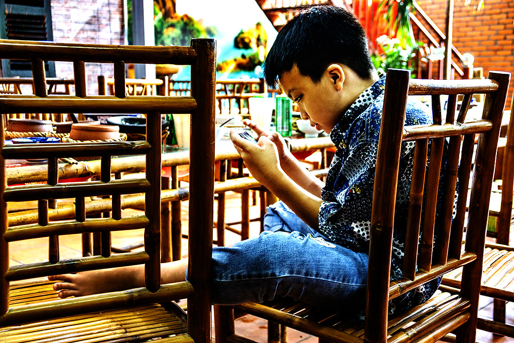 Boy fixated on cellphone in restaurant on 8-15-22--Vung Tau copy