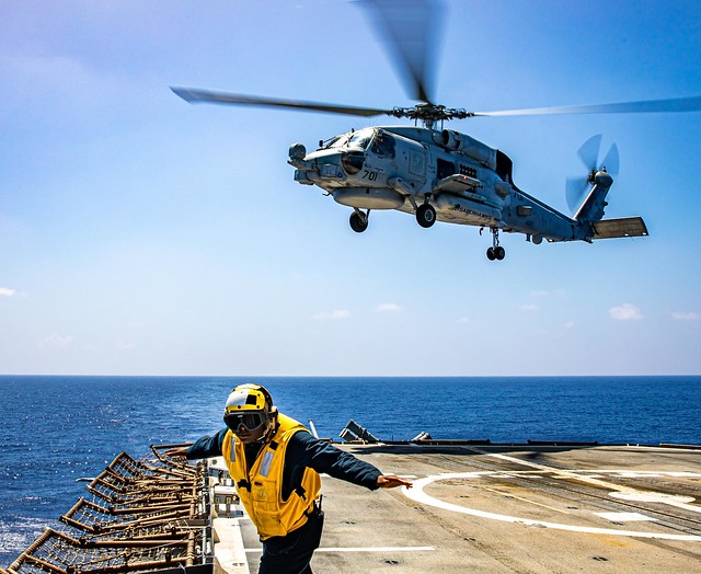 Boatswain's Mate 3rd Class Quincy Nelson signals an MH-60R Sea Hawk helicopter during flight operations aboard USS Chancellorsville (CG 62).