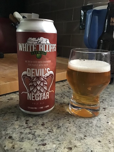 White Bluffs brewing Devil's Nectar can and beer in a glass on counter