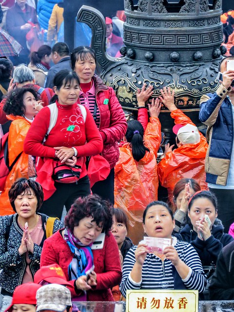 People making a wish in front of the giant statue of Bodhisattva Guanyin