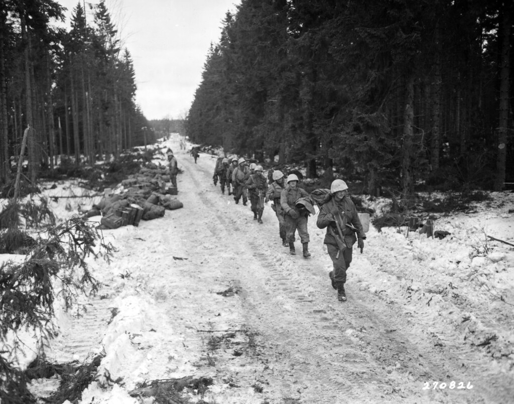 SC 270826 - Infantrymen of the 39th Inf. Regt., 9th Inf. Div., move up road which yesterday was a battlefield in the Wahlerscheid area, of Germany. 2 February, 1945.