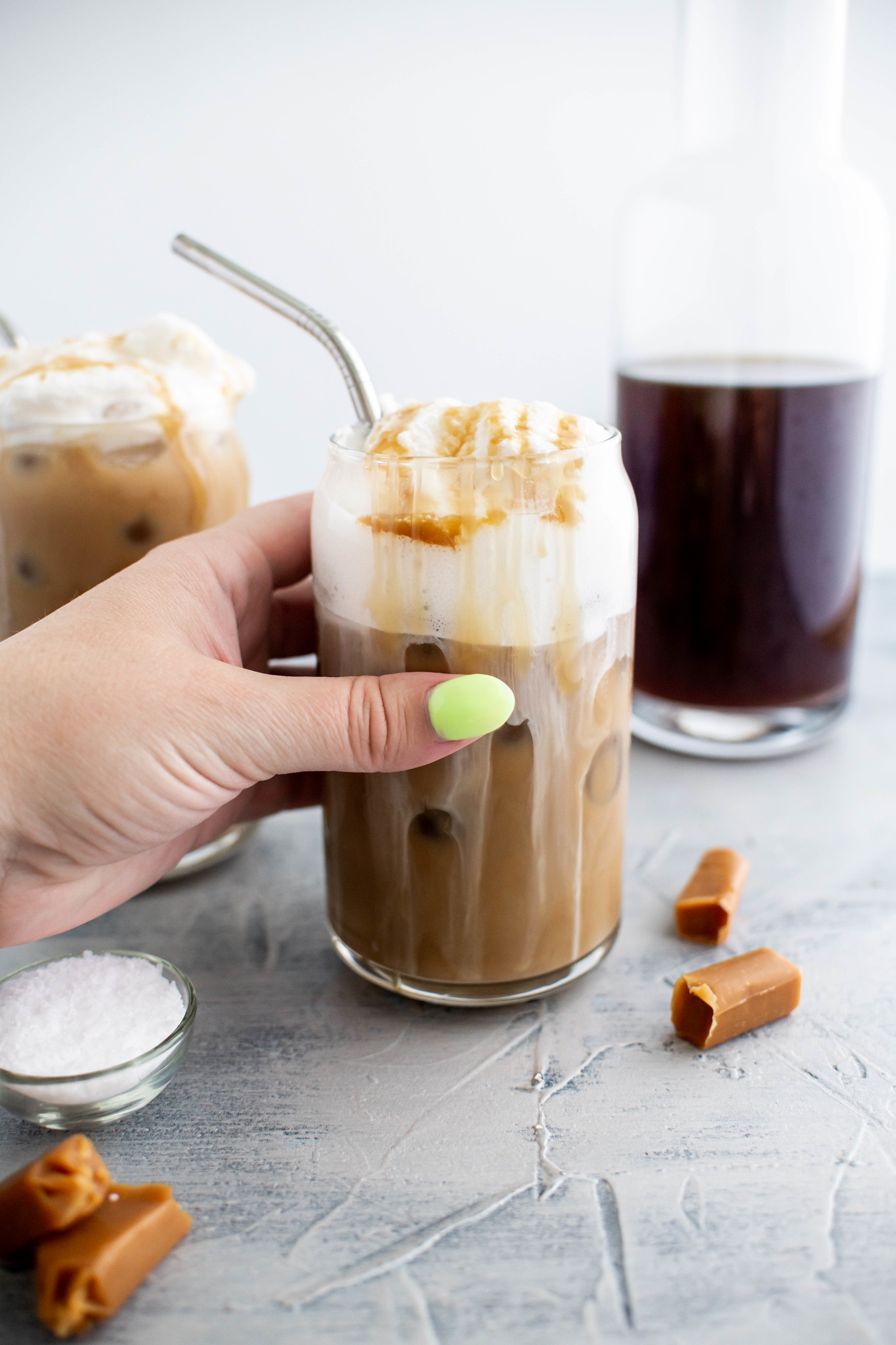 Hand reaching for caramel cold brew.