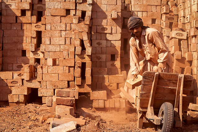 Pakistani worker stacks bricks