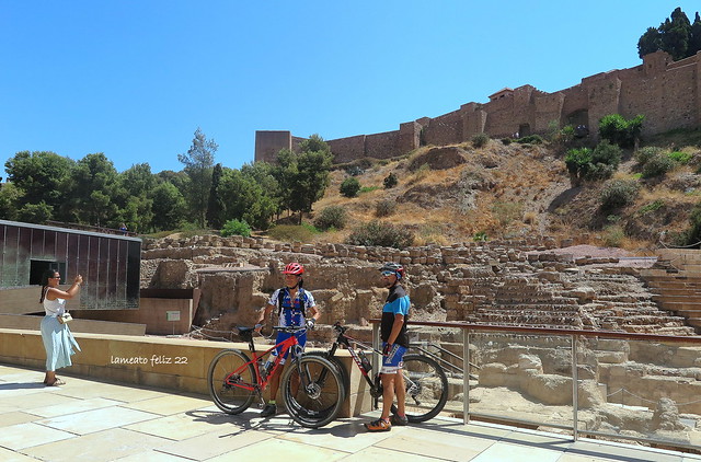 Ciclistas ante el Teatro romano y  las murallas de la Alcazaba. Málaga.
