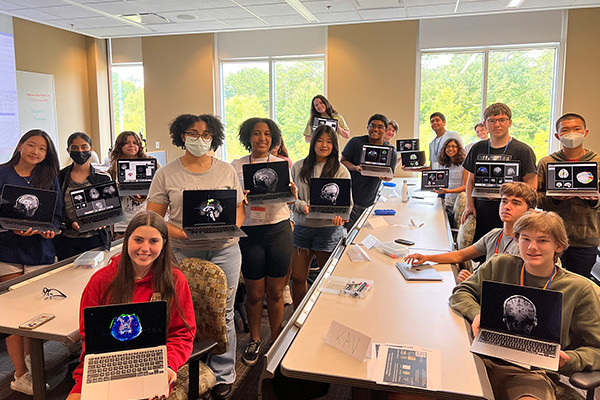 Students hold scans of their brains at Auburn University Brain Camp.