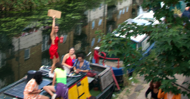 DSC_8641a Notting Hill Caribbean Carnival London Monday August 29 2022 Regents Canal Lady in Red Dress on a Barge Advertising Beer @ £4