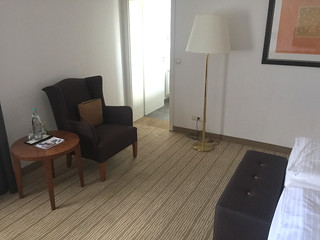 Room in Hotel Heinz - Armchair, table & door to bathroom / Zimmer im Hotel Heinz - Sessel, Tisch & Tür zum Bad
