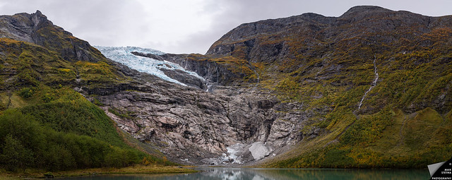 Der zurückgezogene Bøyabreen Gletschers lässt die glattgeschliffene Felswand zurück und sein Wasser läuft im See Brevatnet über Wasserfälle und Bäche zusammen.