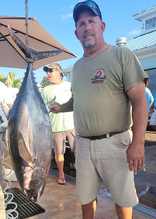 Photo of man with a longfin tuna he caught
