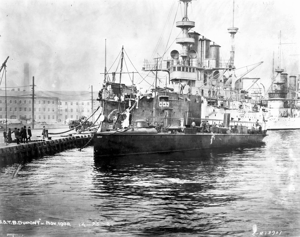 USS Dupont TB7 is front of the USS New York CA2 in November of 1900 at unknown Navy Yard.