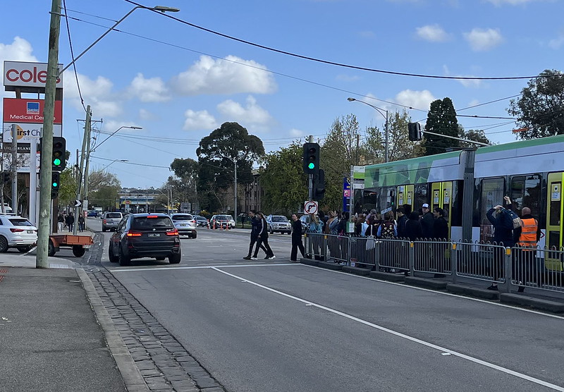 Passengers wait to cross Epsom Road to get to the Showgrounds, after alighting the tram