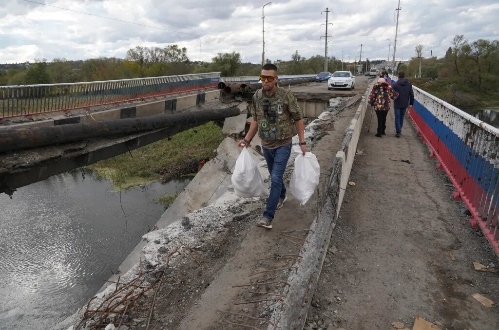 FOTOGRAFÍA. PETROPAVLIVKA (JÁRKOV) UCRANIA, 05.10.2022. Ciudadanos ucranianos cruzan un puente en la aldea de Petropavlivka, recientemente recuperada, en la región de Járkov. Efe