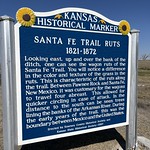 Historical Marker, near Lakin Kansas KANSAS
HISTORICAL MARKER
SANTA FE TRAIL RUTS
1821-1872
Looking east, up and over the bank of the
ditch,
one can
Santa Fe Trail.
see the wagon ruts of the
You will notice a difference
in the color and texture of the grass in the
ruts.
This is characteristic of the ruts along
the trail. Between Pawnee Rock and Santa Fe,
New Mexico, it was customary for the wagons
to travel four
abreast.
This allowed for
quicker circling in case of attack. In the
distance
to the south can be seen trees
lining the banks of the Arkansas River. During
the early years of the trail, this was the
boundary between Mexico and the United States.
Erected by Kearney County Historical Society and
Kansas State Historical Society-1987
