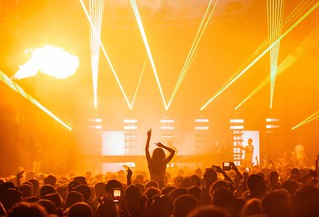 Beautiful shot of a live concert performance with a yellow light show and a big crowd cheering