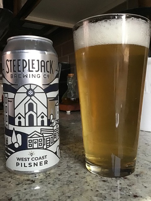 Steeplejack's West Coast Pilsner can next to a glass of same, on kitchen counter