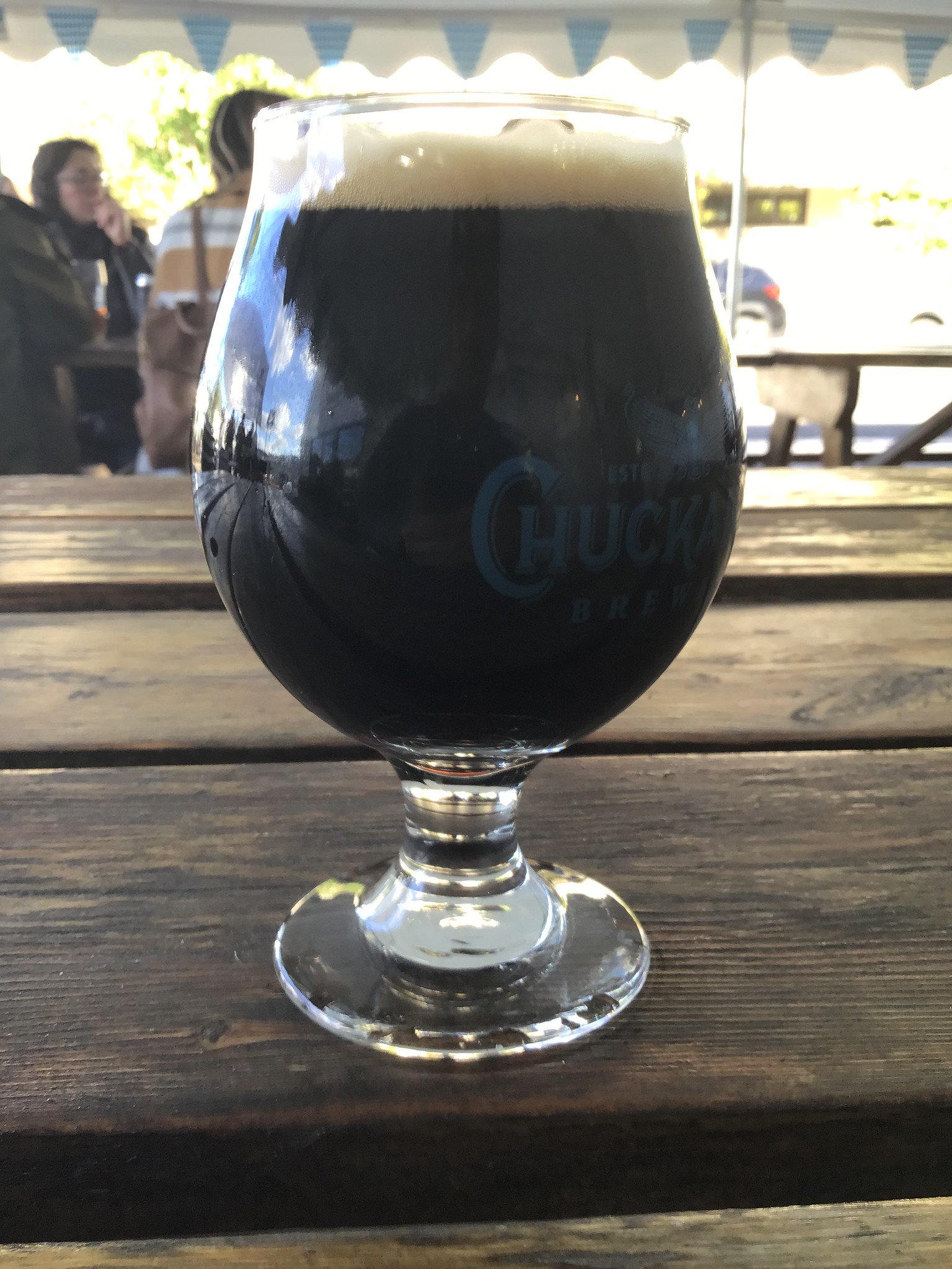 Chuckanut barrel aged stout in a glass on a table outdoors