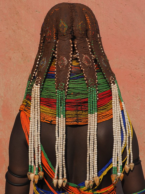 Mwila wearing six Nontombi mud-coated dreadlocks with long beaded extensions