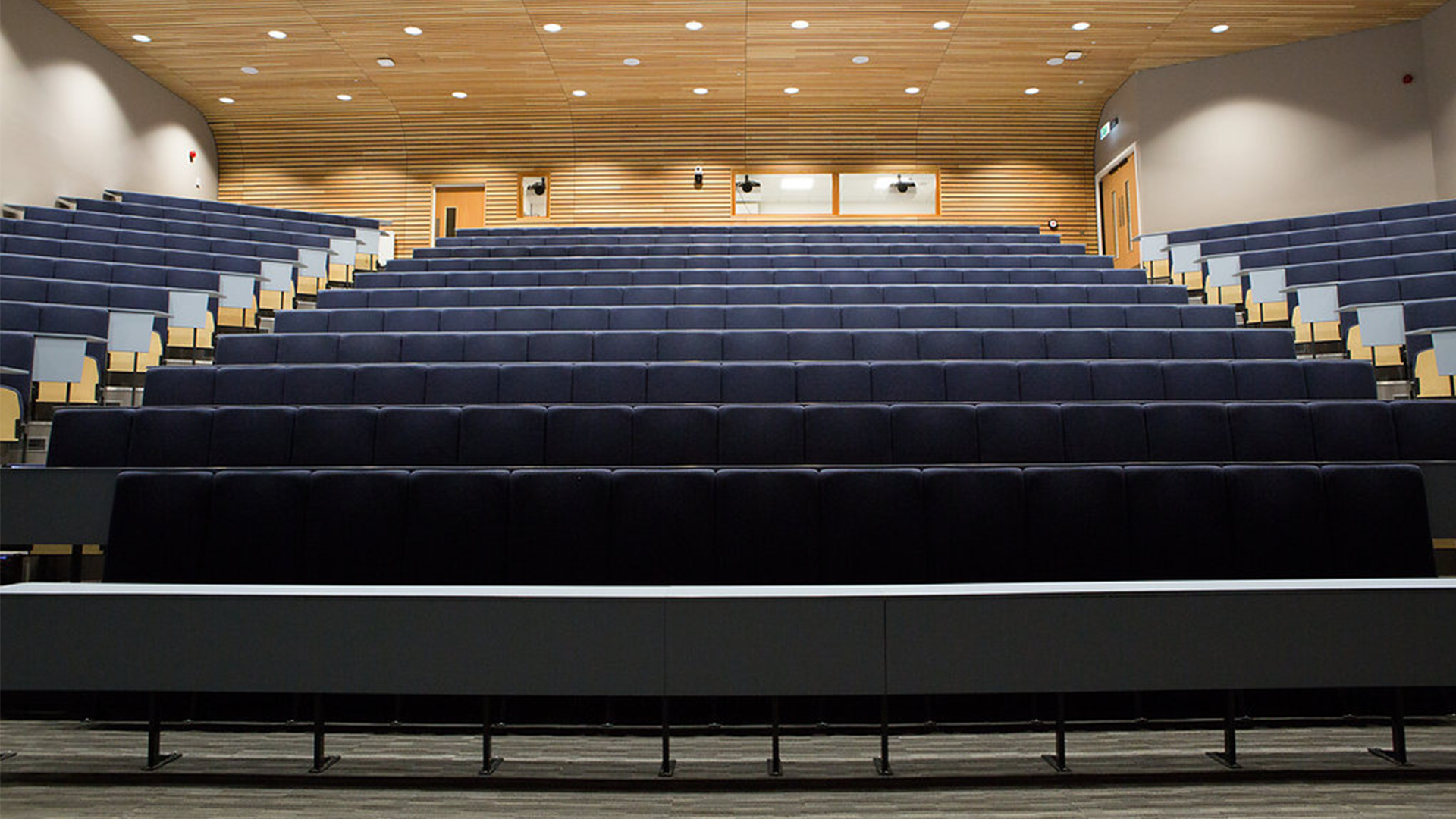 Tiered lecture theatre with students seated and walking through