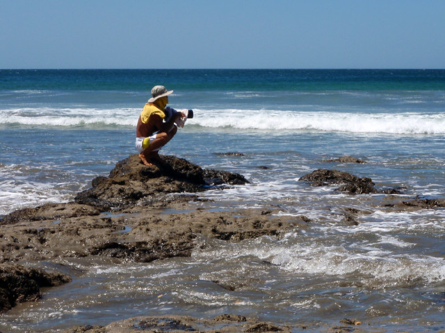 A photographer on the rocks at Playa Negra in Costa Rica